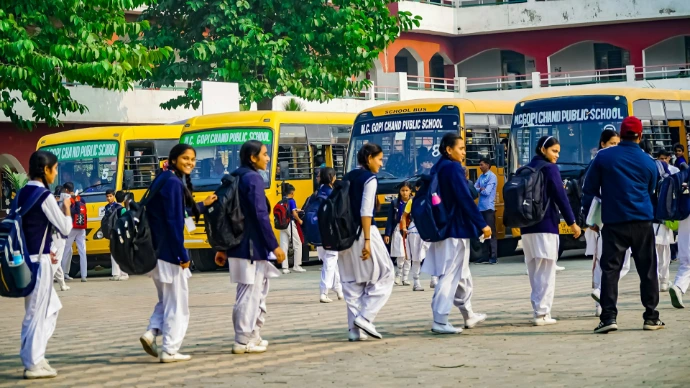 A group of men walking down a street next to buses
